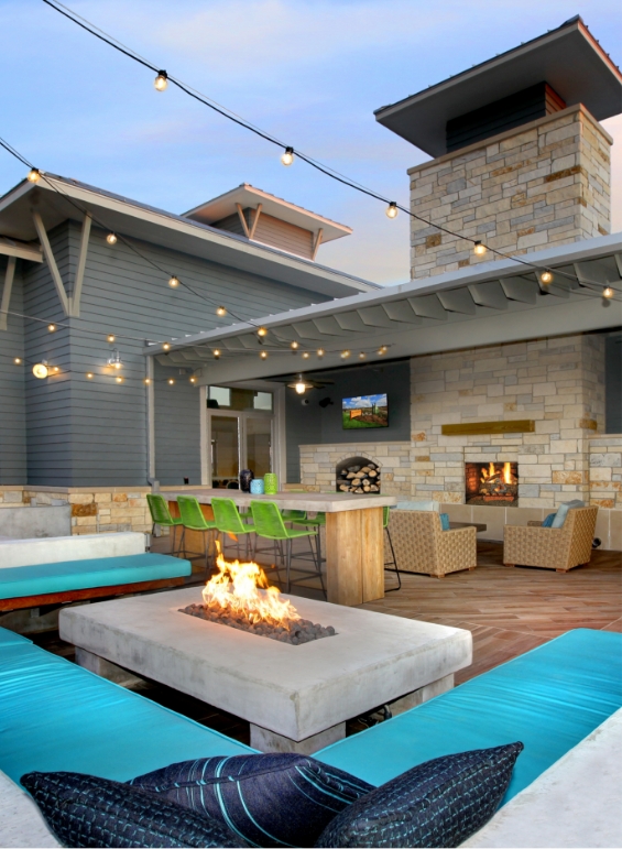 The outdoor seating area at Pomona with a fireplace and teal couches