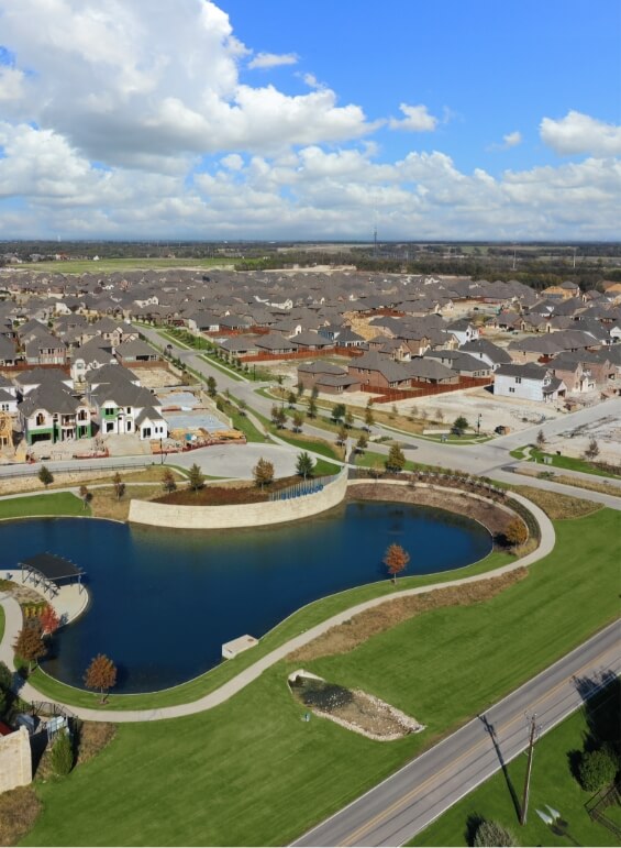 A bird's eye view of the lake at Bluewood with beautiful homes in the background