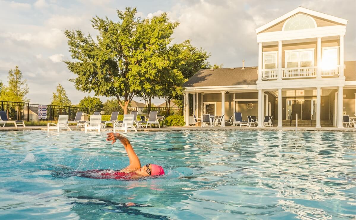 A woman swimming laps at the pool at one of the Lifestyle by Hillwood communities.