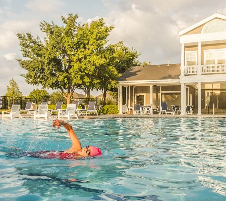 A woman swimming laps at the pool at one of the Lifestyle by Hillwood communities.