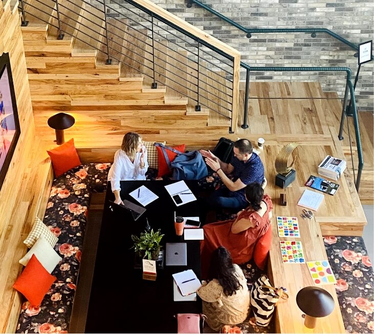 A group of men and women taking part in a meeting at their Lifestyle by Hillwood community's co-working space.