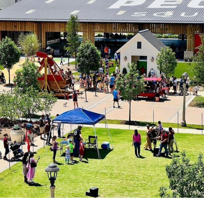 Families enjoying an active community event taking place on the Lawn at Pecan Square in Northlake, Texas.