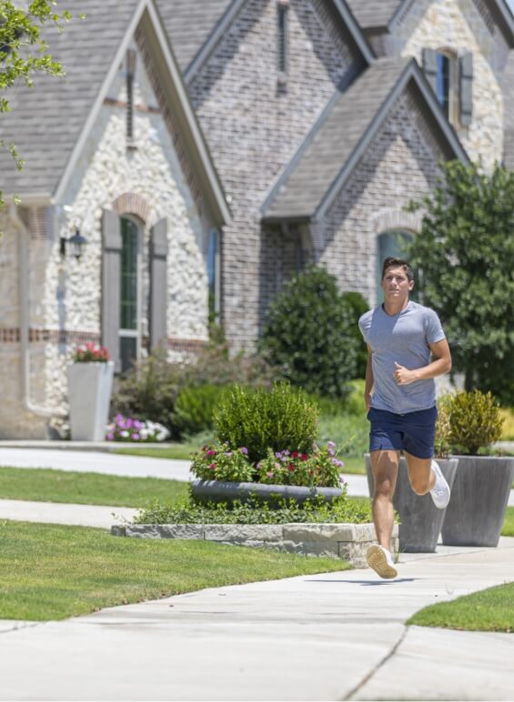 A man running along a sidewalk amidst the homes in Lilyana