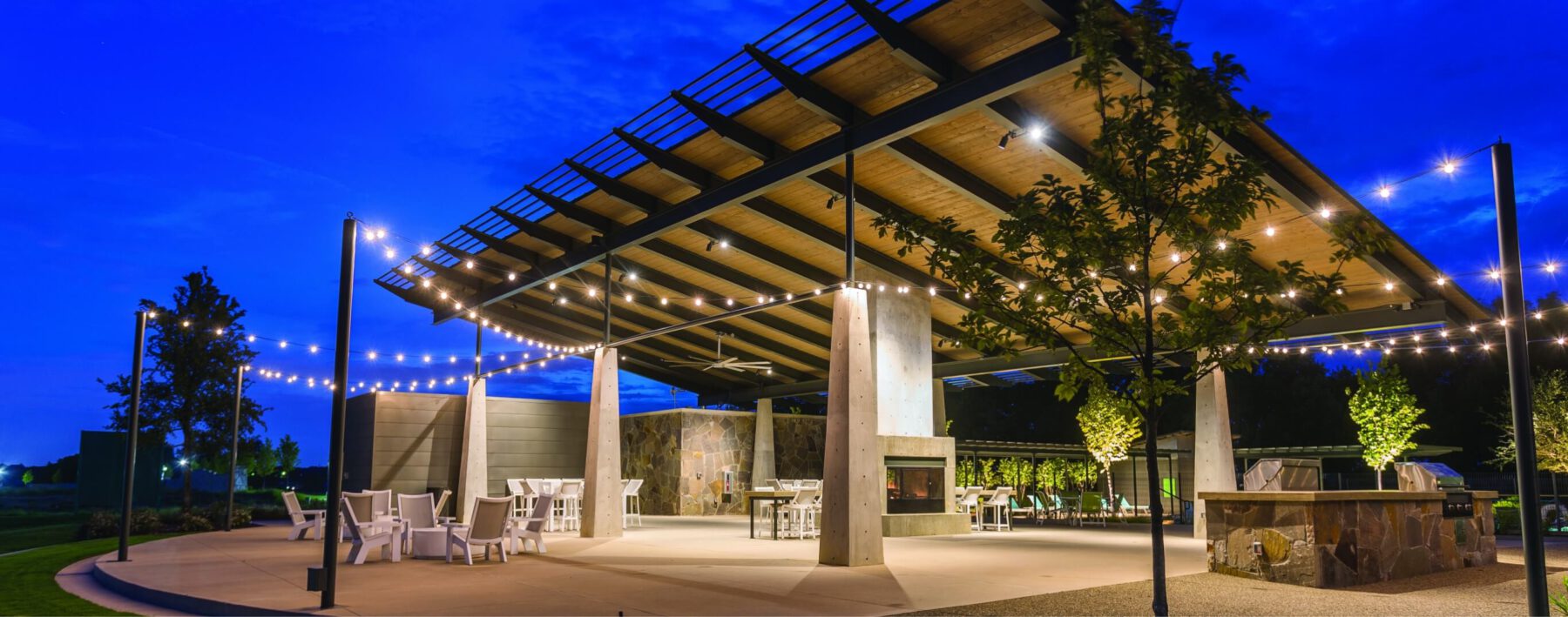 The covered community patio at Lilyana with a fireplace and seating areas.