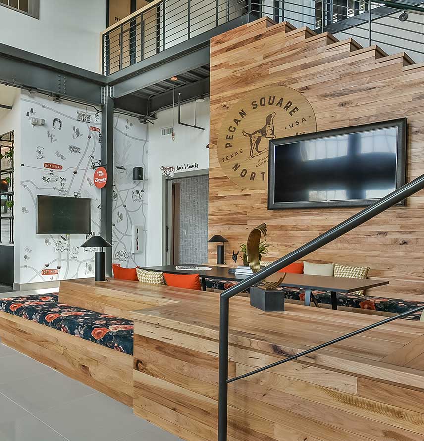 Interior of a Pecan Square building with a staircase, tv, and communal seating