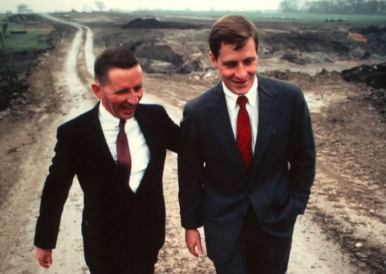 A young Ross Perot, Jr. walking along a dirt road with his father, Ross Perot, Sr.