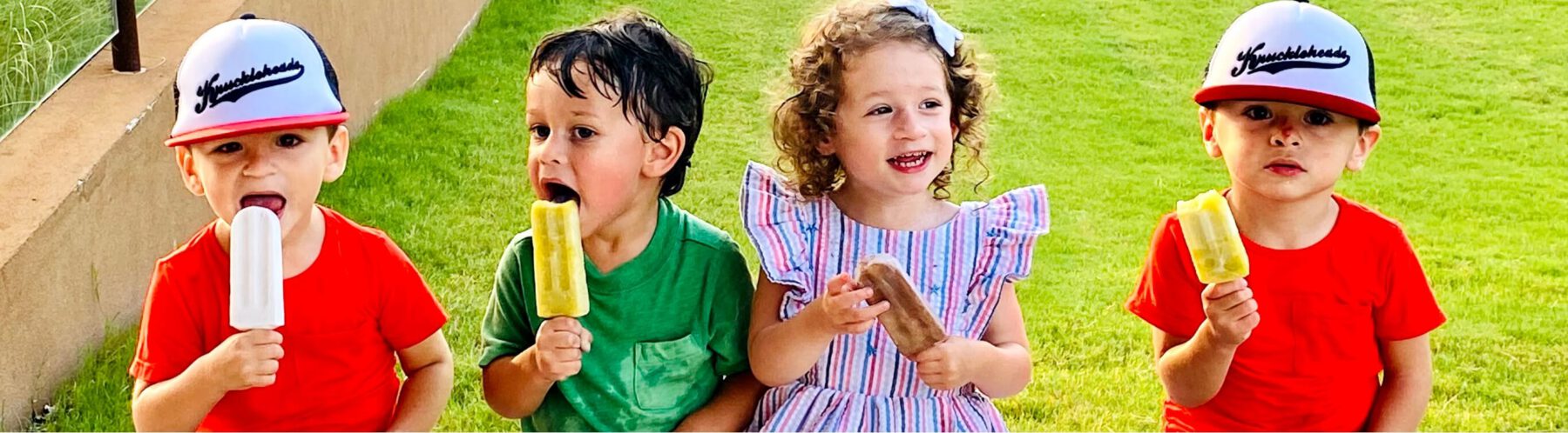 Four young kids enjoying popsicles on a sunny and beautiful Texas day