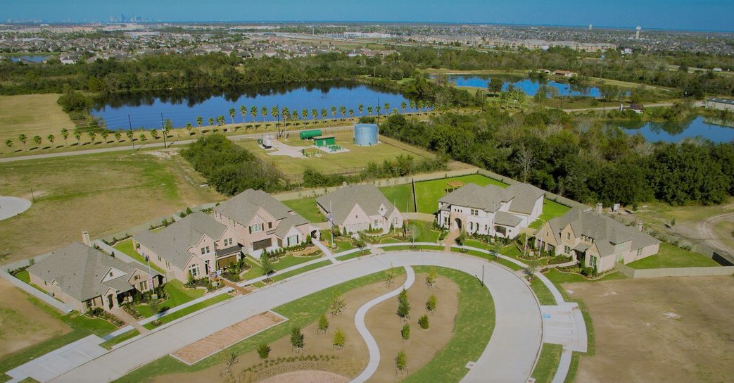 A street scape of houses with lakes in the background in a Lifestyle by Hillwood community
