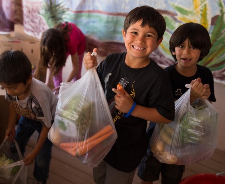 Kids receiving donated fresh fruits and vegetables from the North Texas Food Bank