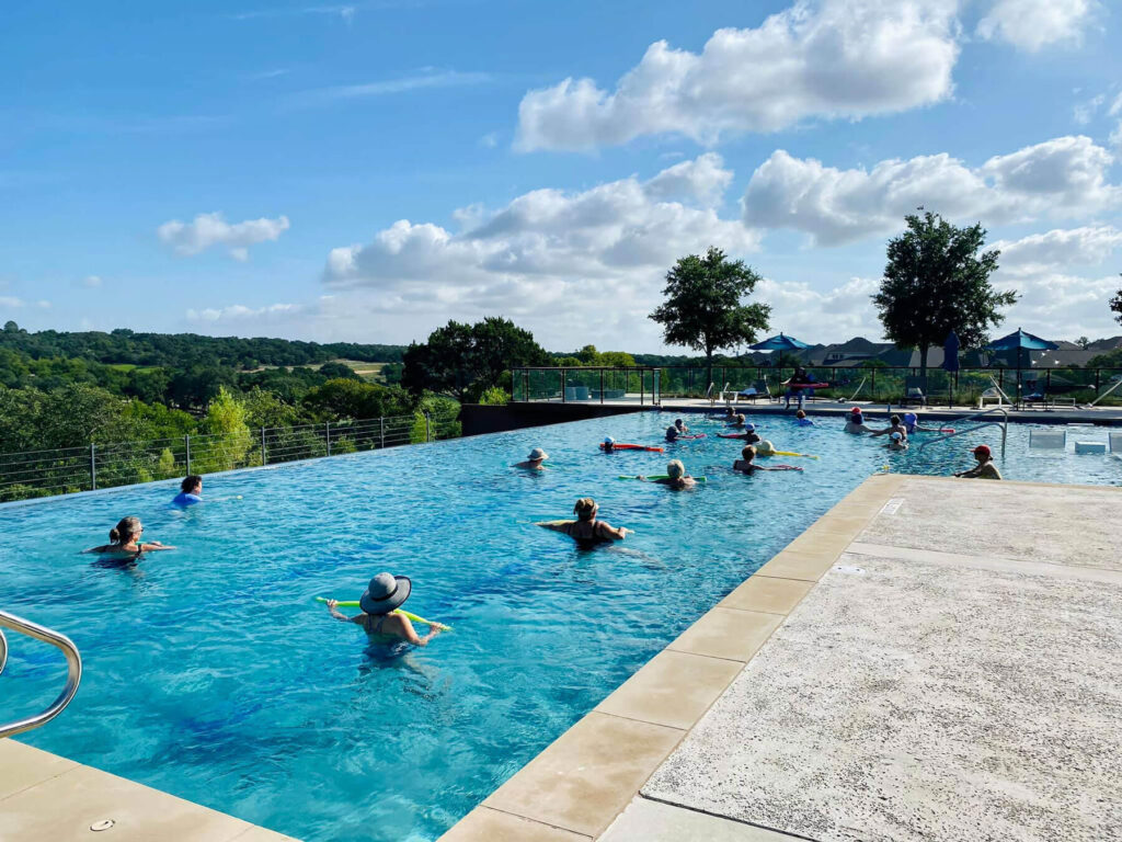 A water aerobics class taking place at the infinity pool in Wolf Ranch
